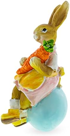 Най-добрата Мама-Зайка-писанка, держащая Морков и седнала на фигурке Великденски яйца